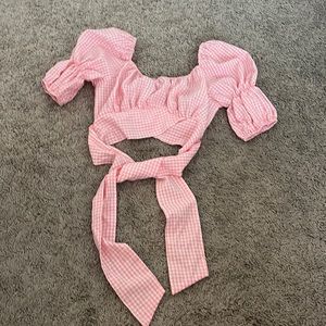 Pink gingham cropped top with puffed sleeves and a tie waist.